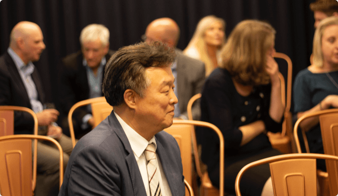 Photo showing Korea expert in front of a room with business people