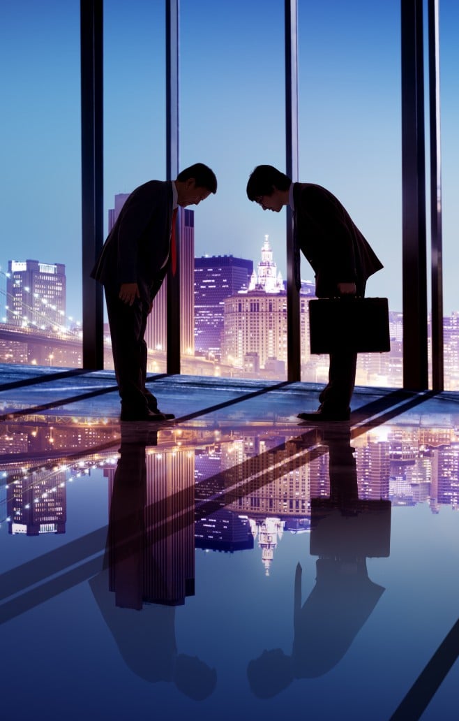 Two men bowing to each other, Japanese city